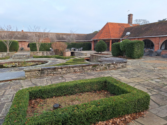 Milton Hill House Hotel - part of the Italian garden, with a terrasse in the background with tables and chairs
